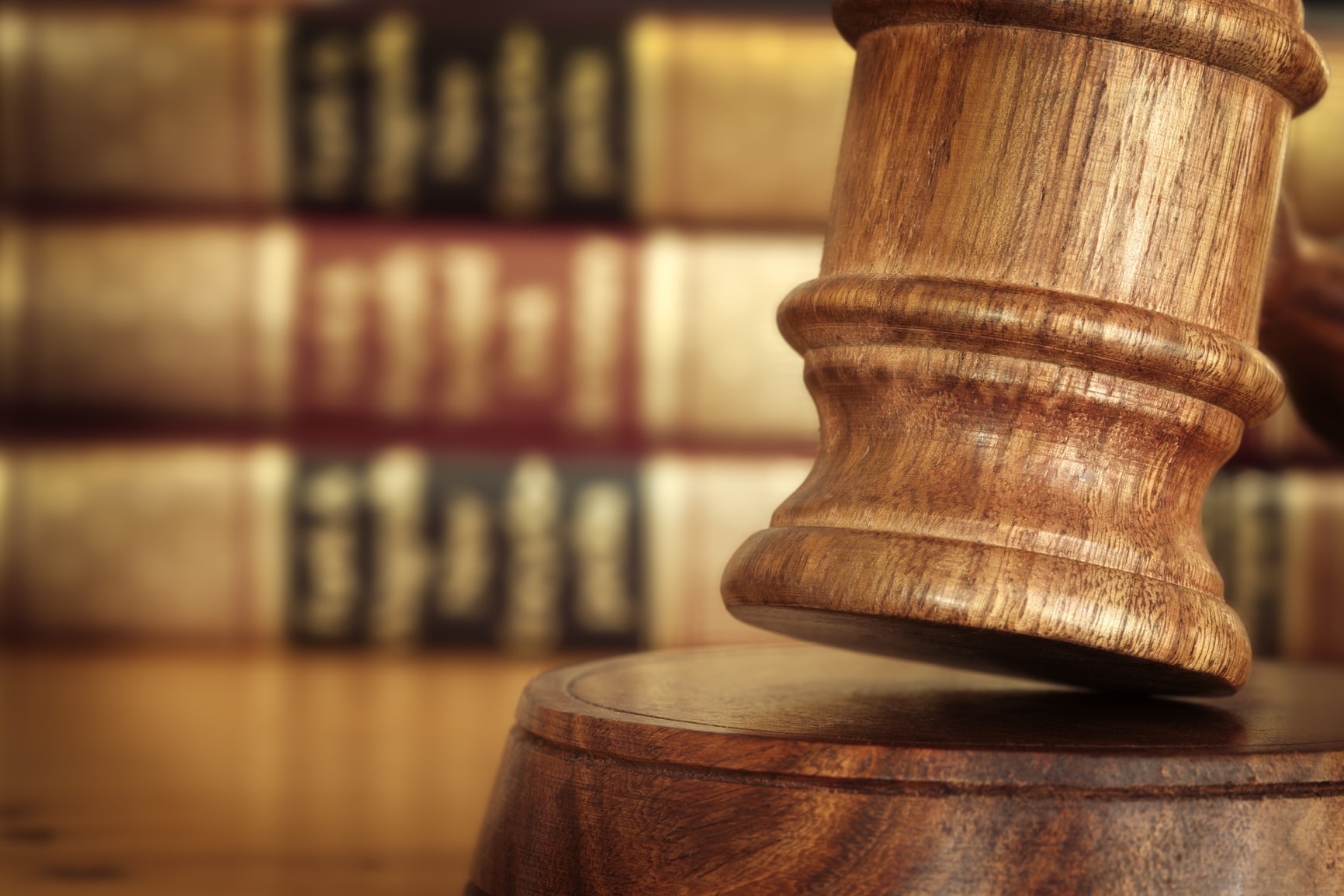 Gavel resting in front of law books, representing the legal guidance provided by a residential real estate lawyer in Warwick, Rhode Island for property transactions.